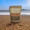 Astro Solar Strength Raw Gold Sea Moss package on beach background.